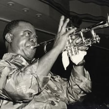 Louis Armstrong playing trumpet during a performance.