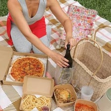 People placing food into a picnic hamper.