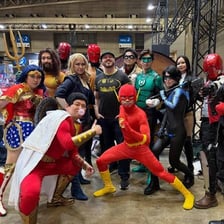 Convention attendees and displays featuring DC Comics superheroes