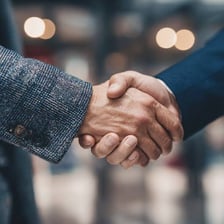 Two people shaking hands to signal agreement