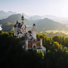 Neuschwanstein Castle stands on a wooded hill in Bavaria.