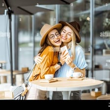 Two people sitting together at a cafe table with coffee.