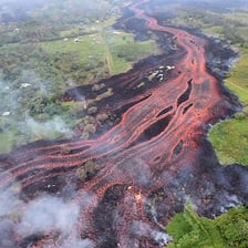 Bright orange lava flowing from a volcanic crater.