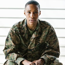 A military uniform hanging in an empty barracks room.