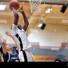 A basketball player completing a slam dunk