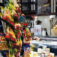 A deli counter displaying prepared foods and sandwiches.