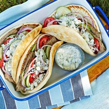 A gyro wrapped in pita bread with tzatziki.