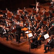 An orchestra performing the concluding number of a concert