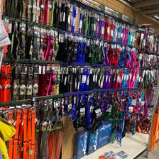 A pet-store aisle displaying dog toys, bowls, and leashes