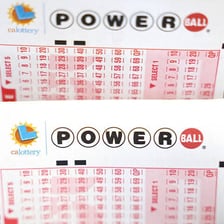 A Powerball lottery ticket beside numbered lottery balls