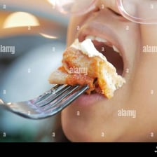 A bite of appetizing food held on a fork.