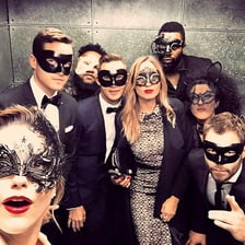 Guests in formal clothing and masks at a masquerade ball