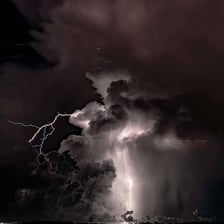 Lightning flashes beneath dark storm clouds.