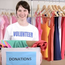 A person donating clothing to a charity