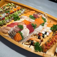 An assortment of sushi served on a boat-shaped platter.