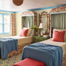 A neatly made bed in a bed-and-breakfast guest room.