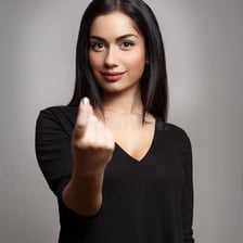 One person quietly signaling to get another person's attention.