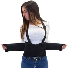 A person standing while wearing supportive shoes and a lumbar support belt
