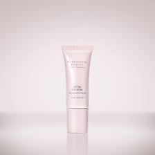 A jar of eye cream beside skincare packaging