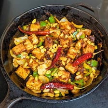A serving of kung pao tofu with vegetables and sauce.