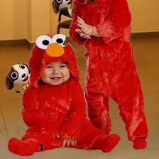 A toddler wears a red Elmo costume for Halloween.