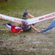 A runner crossing a race finish line first