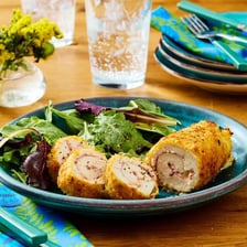 A plated chicken cordon bleu cut open to show its filling