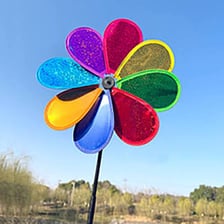A colorful pinwheel spinning outdoors.
