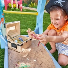 A toddler playing in a sandbox