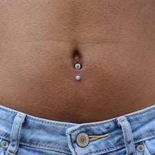 A close view of a navel with a belly-button piercing.