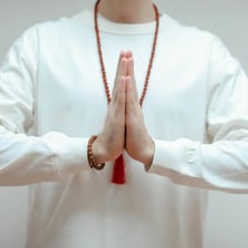 A person greeting with palms pressed together in front of the chest