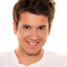 A smiling person conveying a pleasant manner.