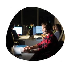 Office workers receiving technical support at computers.