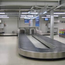 A suitcase traveling on an airport baggage carousel.