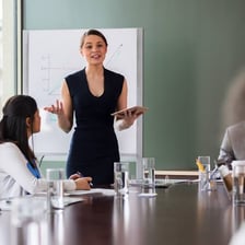 A person speaking to a group during a meeting.