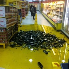 A spill of groceries creating a mess in a supermarket aisle.