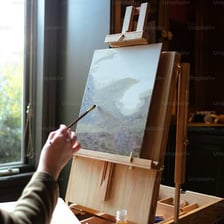 An easel holding a canvas in an art studio.
