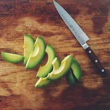 A ripe avocado cut open to show its green flesh.