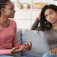 A person giving an awkward, mildly skeptical reaction during a conversation