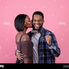 A person giving another person a brief kiss on the cheek