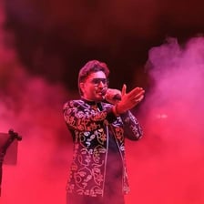 A singer performing into a microphone on stage