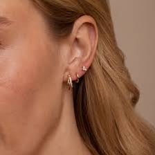 An ear wearing a stud earring and a hoop earring.