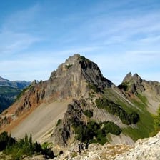 A pointed mountain summit representing a pinnacle.