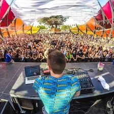 A DJ performing electronic dance music for a festival crowd