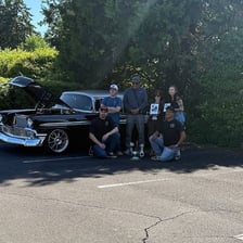 Automobile enthusiasts working on a car.
