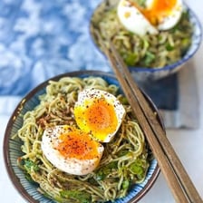 A bowl of ramen topped with a halved soft-boiled egg.