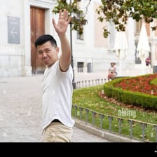A person waves while saying goodbye.