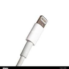 A USB cable beside the matching charging port on an electronic device.