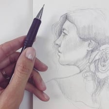 An artist making a pencil sketch on paper.