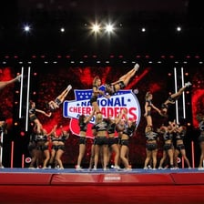 A cheerleading team performing a stunt and tumbling routine